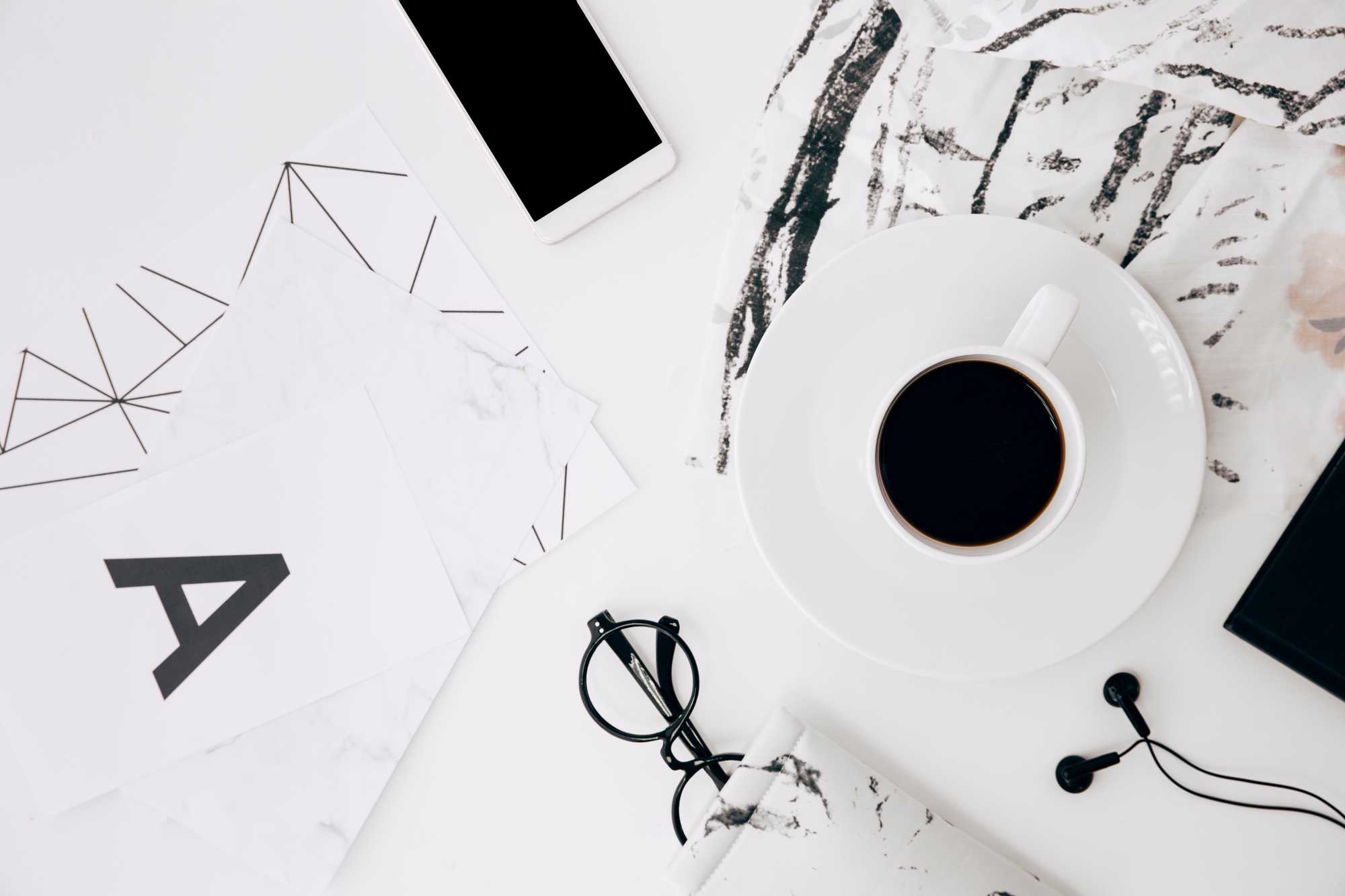 letter-eyeglasses-smartphone-earphone-coffee-cup-white-desk letter-eyeglasses-smartphone-earphone-coffee-cup-white-desk